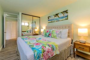a bedroom with a large bed and a mirror at Kahana Reef 205 by Coldwell Banker Island Vacations in Kahana
