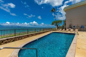 a swimming pool with a view of the ocean at Kahana Reef 205 by Coldwell Banker Island Vacations in Kahana