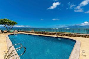 a swimming pool with a view of the water at Kahana Reef 205 by Coldwell Banker Island Vacations in Kahana +25 photos