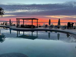 a swimming pool with a gazebo and a sunset at La Posada Hotel Boutique in La Paz