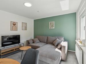 エメリッヒにあるSali Homes-Komfort Apartment Haus in Emmerich am Rheinのソファとテレビのあるリビングルーム