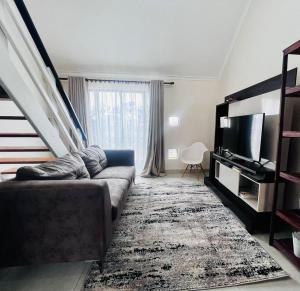 a living room with a couch and a television at Loft On Grosvenor in Pretoria