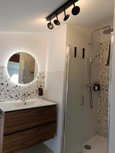 a bathroom with a sink and a shower with a mirror at Maison Irondas in Saint-Pierre-dʼAurillac