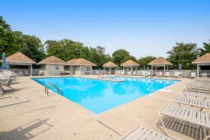 a pool at a resort with chairs and trees at Savannahs Landing --- 10 Mary Elizabeth Dr in Ocean View