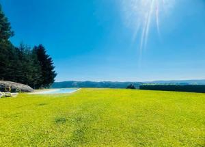 a large grassy field with a pond in the background at Escusa in Baião