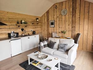 a living room with a couch and a table at Edgmond Lodges - 1 & 2 Bed Luxury Log Cabins with Private Hot Tubs Derbyshire in Hilton