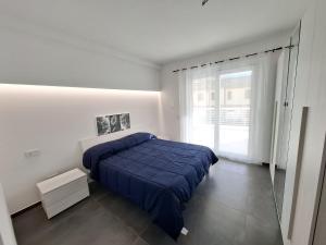 a bedroom with a blue bed and a window at Appartamento Leon in Roseto degli Abruzzi