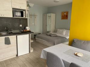 Habitación con 2 camas y cocina con fregadero. en Apartments Siyana Varna, en Varna
