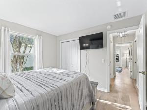 a white bedroom with a bed and a flat screen tv at 3270 Z2A VILLAGE OF GLENBROOK by REMAX Premier in The Villages