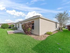 a small white house with a green yard at 3270 Z2A VILLAGE OF GLENBROOK by REMAX Premier in The Villages