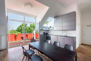 a kitchen with a dining room table and chairs at Sky Loft Leipzig - moderne Dachwohnung mit Terrasse und Blick aufs Rathaus in Leipzig