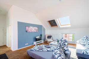 a living room with two beds and a couch at Sky Loft Leipzig - moderne Dachwohnung mit Terrasse und Blick aufs Rathaus in Leipzig