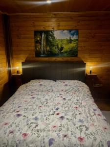 a bedroom with a bed with a painting on the wall at Stara hiža pod Okićem in Jastrebarsko