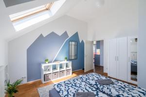 a bedroom with a bed and a blue wall at Sky Loft Leipzig - moderne Dachwohnung mit Terrasse und Blick aufs Rathaus in Leipzig