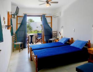 a bedroom with a bed with blue sheets and a window at fi naxos in Agios Prokopios