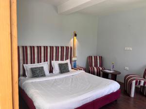 A bed or beds in a room at Resort Apple Flower by Rohtang Family Hotels- Balcony & Mountain View, Near Mall Road, Personal Parking