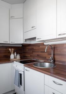 una cucina con mobili bianchi e un lavandino di Valoisa 44,5 m2 kaksio Lahden keskustassa a Lahti