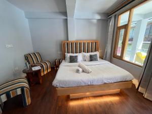 A bed or beds in a room at Resort Apple Flower by Rohtang Family Hotels- Balcony & Mountain View, Near Mall Road, Personal Parking