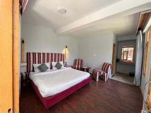A bed or beds in a room at Resort Apple Flower by Rohtang Family Hotels- Balcony & Mountain View, Near Mall Road, Personal Parking