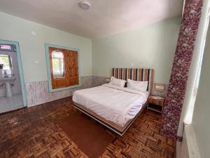 A bed or beds in a room at Resort Apple Flower by Rohtang Family Hotels- Balcony & Mountain View, Near Mall Road, Personal Parking