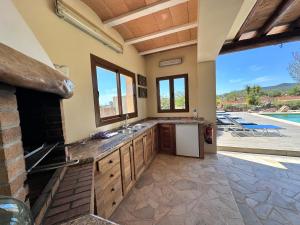 une grande cuisine avec un évier et une piscine dans l'établissement Casa Bet con piscina y jardín., à Sant Miquel de Balansat
