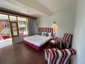 A bed or beds in a room at Resort Apple Flower by Rohtang Family Hotels- Balcony & Mountain View, Near Mall Road, Personal Parking