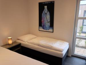 a bed in a room with a picture on the wall at Marina Strandbad Chalet IJssel Lodge Haus Nr 34 in Olburgen +16 photos
