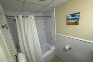 e bagno con doccia e tenda bianca. di Courtyard Resort a Hyannis Altre 10 foto