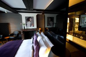 a bedroom with a bed with a fireplace and portraits at Canal House in Amsterdam