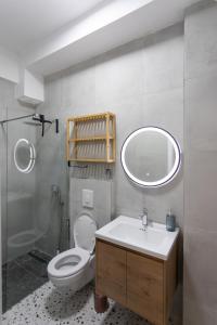 a bathroom with a toilet and a sink and a mirror at Brand new apartment close to the beach Ap 3 in Sarandë +18 photos