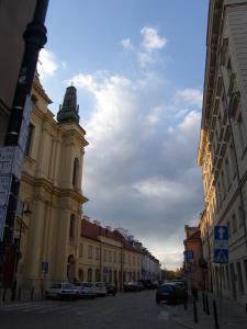 ワルシャワにあるMurano Apartaments Old Townの時計塔のある建物のある街道