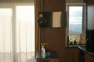 a kitchen with a window and a table with flowers at Urban Grove Apartment in Floreşti