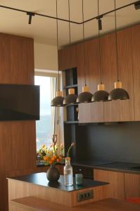 a kitchen with wooden cabinets and a black counter top at Urban Grove Apartment with Balcony and Free Parking in Floreşti