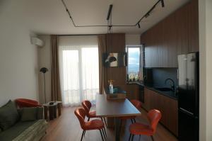 a kitchen and living room with a table and chairs at Urban Grove Apartment with Balcony and Free Parking in Floreşti +20 photos