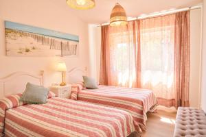 a bedroom with two beds and a window at Apartamento Sear Areas in Sanxenxo