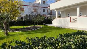 a yard in front of a building with a lawn at VILLA MANIVA in Ginosa Marina