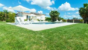 een villa met een zwembad en een huis bij Villa Menea con Piscina e Spa nel Salento in Casarano