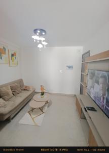 ein Wohnzimmer mit Sofa und Fernseher in der Unterkunft Hermoso Apartamento con piscina in La Playa Bejarano