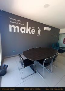 a table and chairs in a room with a make it sign at Hermoso Apartamento con piscina in La Playa Bejarano +13 photos