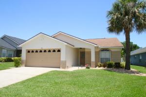 a house with a garage and a palm tree at Family Escape Close to parks in Orlando