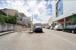 a street with cars parked on the side of the road at O Encanto no Centro de Coimbra in Coimbra