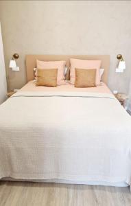 a large white bed with two pillows on it at O Encanto no Centro de Coimbra in Coimbra