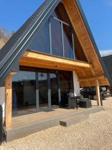 a house with glass windows and a roof at Bungalov La Repit in Šipovo