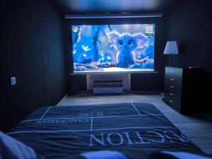 a room with a tv with a movie on the screen at Le cinéma dans le Verdon classé 3 étoiles in Riez +18 photos