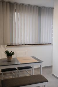 a dining room table with a window with white blinds at Schloss Casa Lauf an der Pegnitz Zimmer Rom in Lauf an der Pegnitz