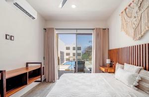 ein Schlafzimmer mit einem Bett und einem großen Fenster in der Unterkunft Departamentos Ámbar in Santa Cruz Huatulco