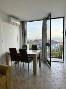 a dining room with a table and chairs and a large window at Casa Vacanze L'Onda in Trinità dʼAgultu