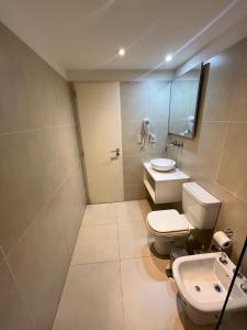 a bathroom with a toilet and a sink and a mirror at Costa Beagle in Ushuaia +9 photos