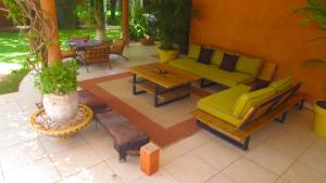 a patio with a green couch and a wooden table at Villa Zehliana in Saly Portudal