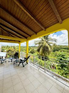 a patio with chairs and tables on a balcony at Duplex in Bouillé